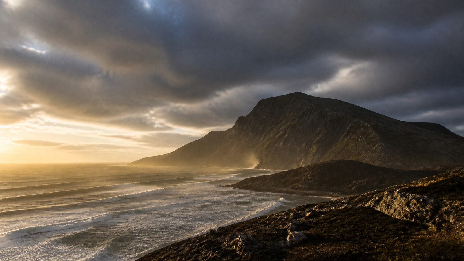 Falaises australes battues par la mer sous une lumière basse près du cap Horn