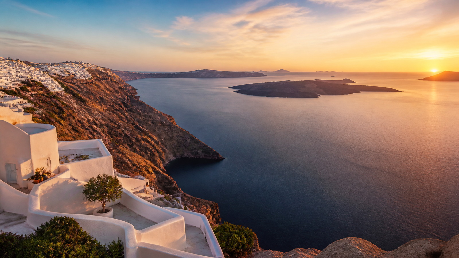 Caldeira des Cyclades au coucher du soleil, village blanc sur la falaise et mer Égée