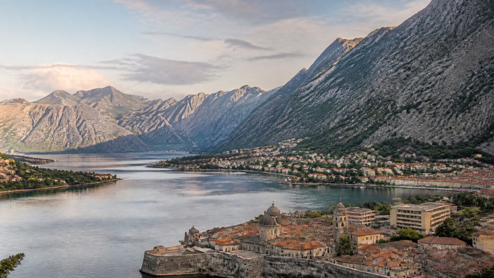 Baie de Kotor au petit matin, vieille ville fortifiée au pied de montagnes calcaires et eau calme