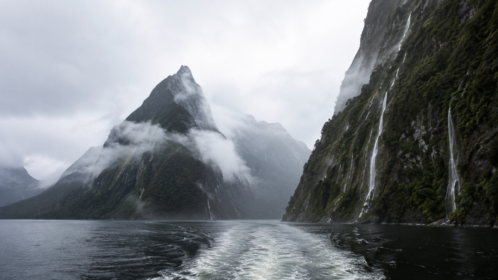 Entrée du fjord de Milford Sound vue depuis le pont d’un navire, Mitre Peak dans les nuages